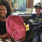 Children receiving backpack
