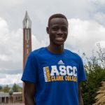 Evans Kaame stands smiling in front of Clark's Chime Tower
