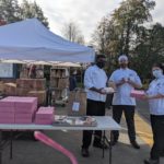 culinary faculty and student holding up food to be distributed curbside