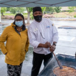 Dr. Edwards and Professor Frederick preparing food outdoors