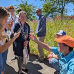 Biology Professor Steven Clark shows staff a bee he caught in the wildflower garden.