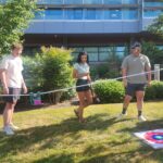 three people watch object move across a string